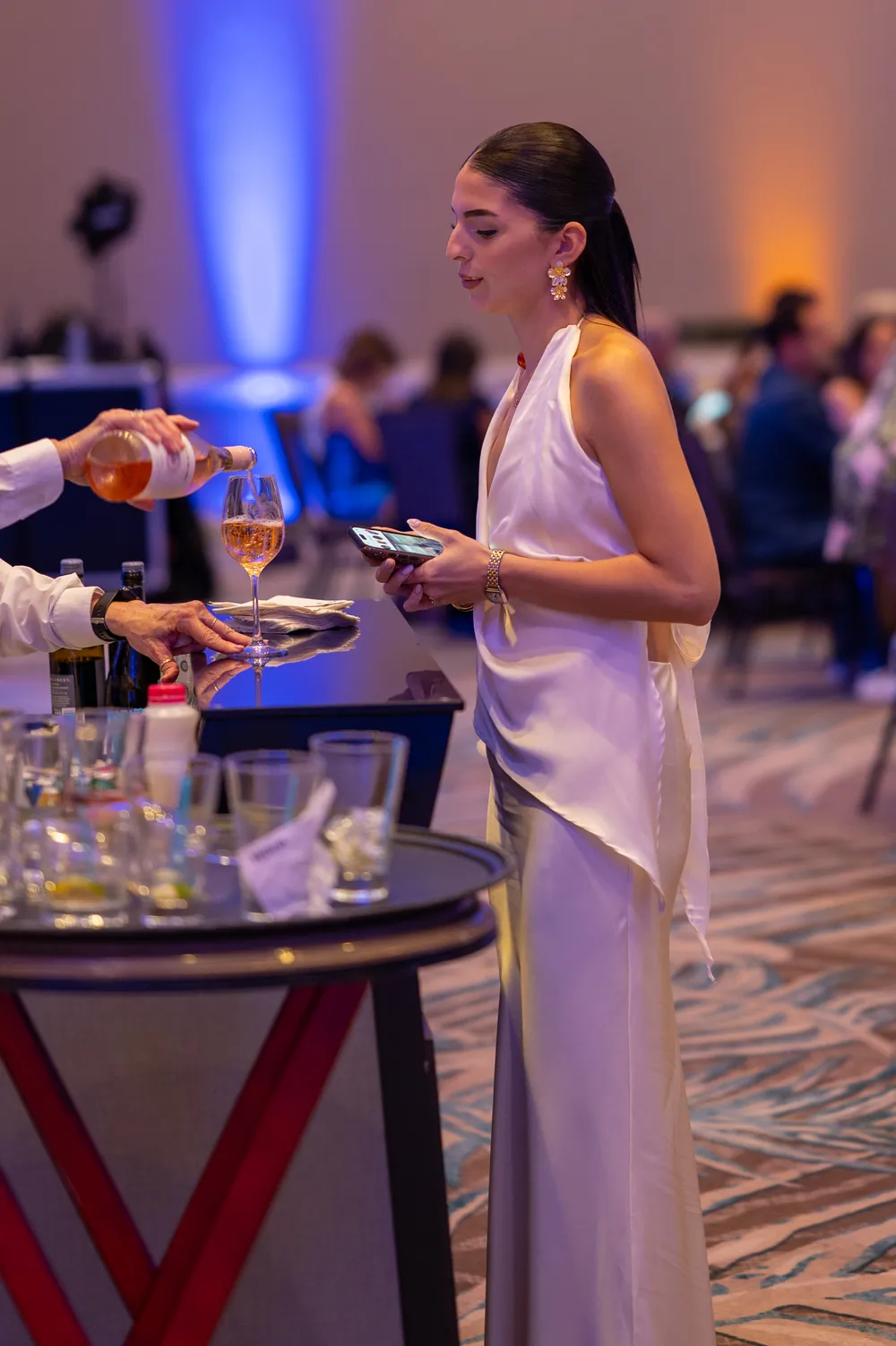 A guest in a white dress enjoys the evening reception.