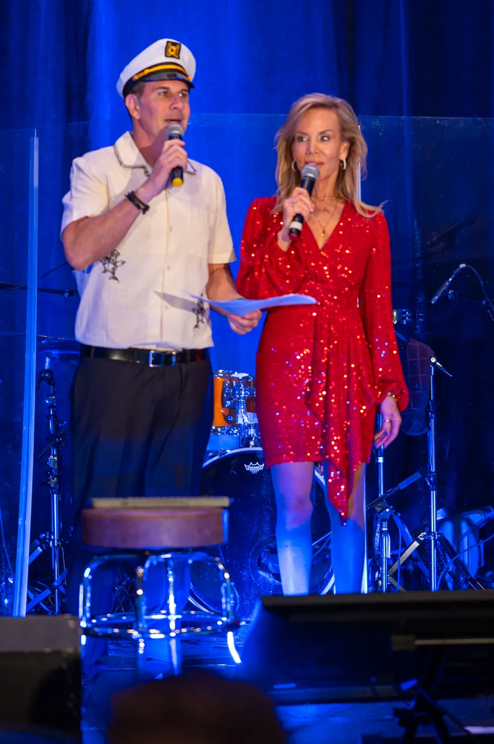 Two speakers address the gala from the blue-lit stage.