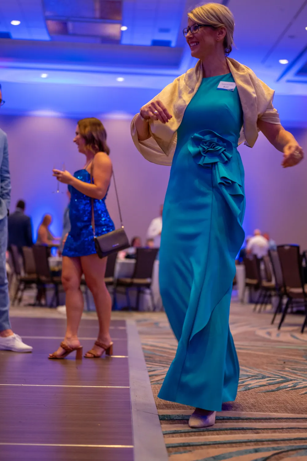 Guests dance together beside the ballroom tables.