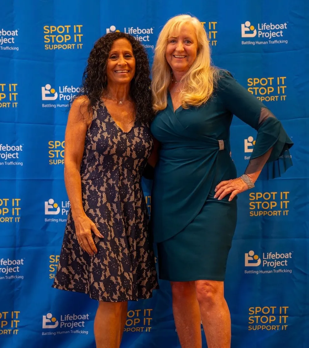 Two guests arrive for a photograph at the gala backdrop.