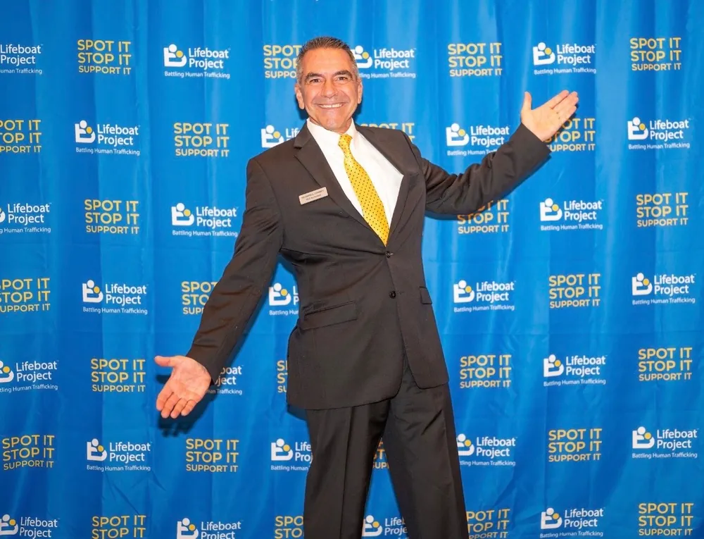 A smiling guest welcomes the camera with open arms.